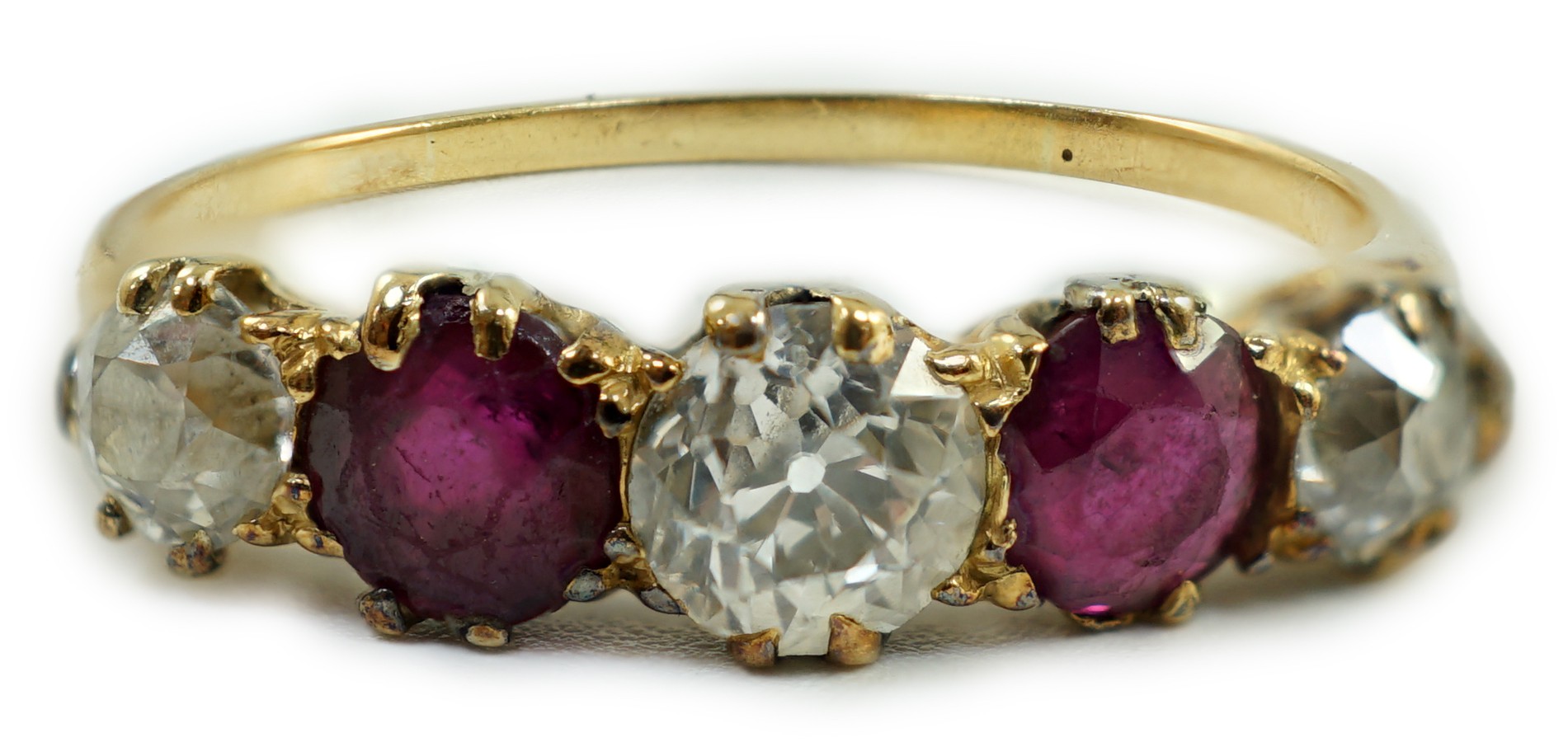 A yellow metal, three stone diamond and two stone ruby set half hoop ring, size V, gross weight 3.2 grams.